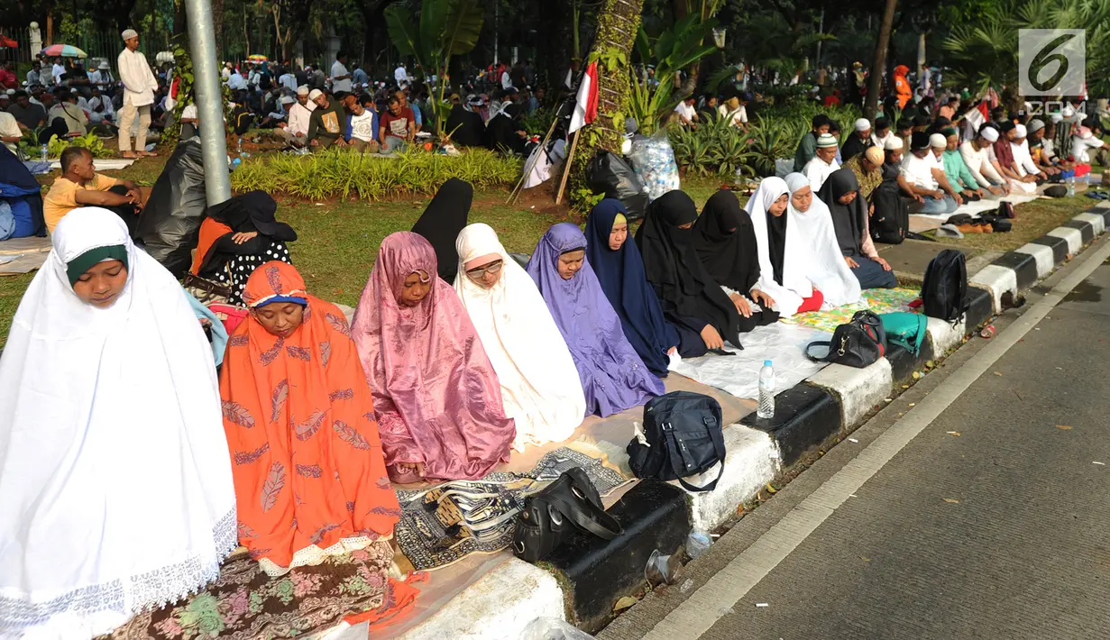 Massa pendukung pasangan capres-cawapres Prabowo Subianto dan Sandiaga Uno melakukan salat asar di Jalan Medan Merdeka Barat, Jakarta, Kamis (27/6/2019). Aksi tersebut dilakukan jelang putusan perselisihan hasil pemilihan umum (PHPU) Pilpres 2019 di Gedung MK. (merdeka.com/Arie Basuki)