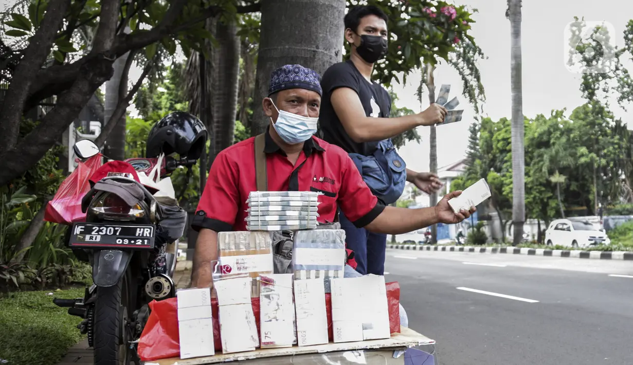 Penjual jasa penukaran uang menawarkan uang baru dalam berbagai pecahan di kawasan Pondok Indah, Jakarta, Kamis (6/5/2021). Penjual jasa musiman tersebut mulai ramai menjelang Lebaran. (Liputan6.com/Johan Tallo)