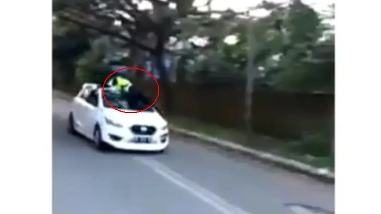 Polisi bertahan di atas mobil Datsun GO
