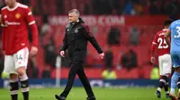 Manajer Manchester United, Ole Gunnar Solskjaer, berjalan tertunduk setelah timnya kalah 0-2 dari Manchester City di Old Trafford, Sabtu (6/11/2021). (OLI SCARFF / AFP)