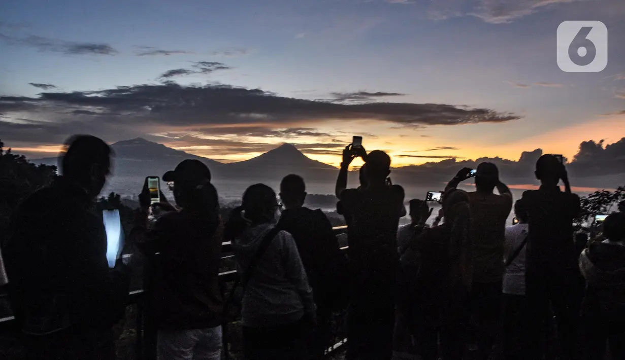 <p>Wisatawan saat mengabadikan momen matahari terbit atau sunrise dengan latar belakang Candi Borobudur di Punthuk Setumbu, Karangrejo, Magelang, Jawa Tengah, Senin (16//5/2022). Punthuk Setumbu menjadi destinasi favorit di Jawa Tengah, terlebih saat libur Waisak yang terkenal dengan keindahan alam Candi Borobudur dan sekitarnya saat matahari terbit. (merdeka.com/Iqbal S. Nugroho)</p>