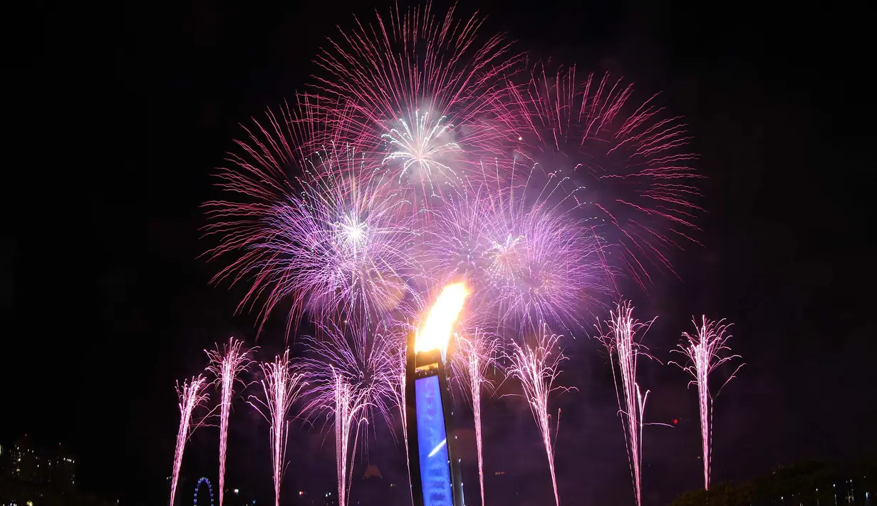 Pesta kembang api yang menjadi latar kaldron api SEA Games menghiasi langit Singapura pada saat Pembukaan SEA Games 2015 di Stadion Nasional Singapura. Jumat (5/6). (Bola.com/Arief Bagus)