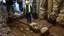 Seorang awak konstruksi bekerja di penggalian situs kuno di bawah pusat kota Thessaloniki, Yunani (25/4). Dalam penggalian ini telah ditemukan lebih dari 300.000 benda penting termasuk 50.000 koin. (AFP/Aris Messinis)