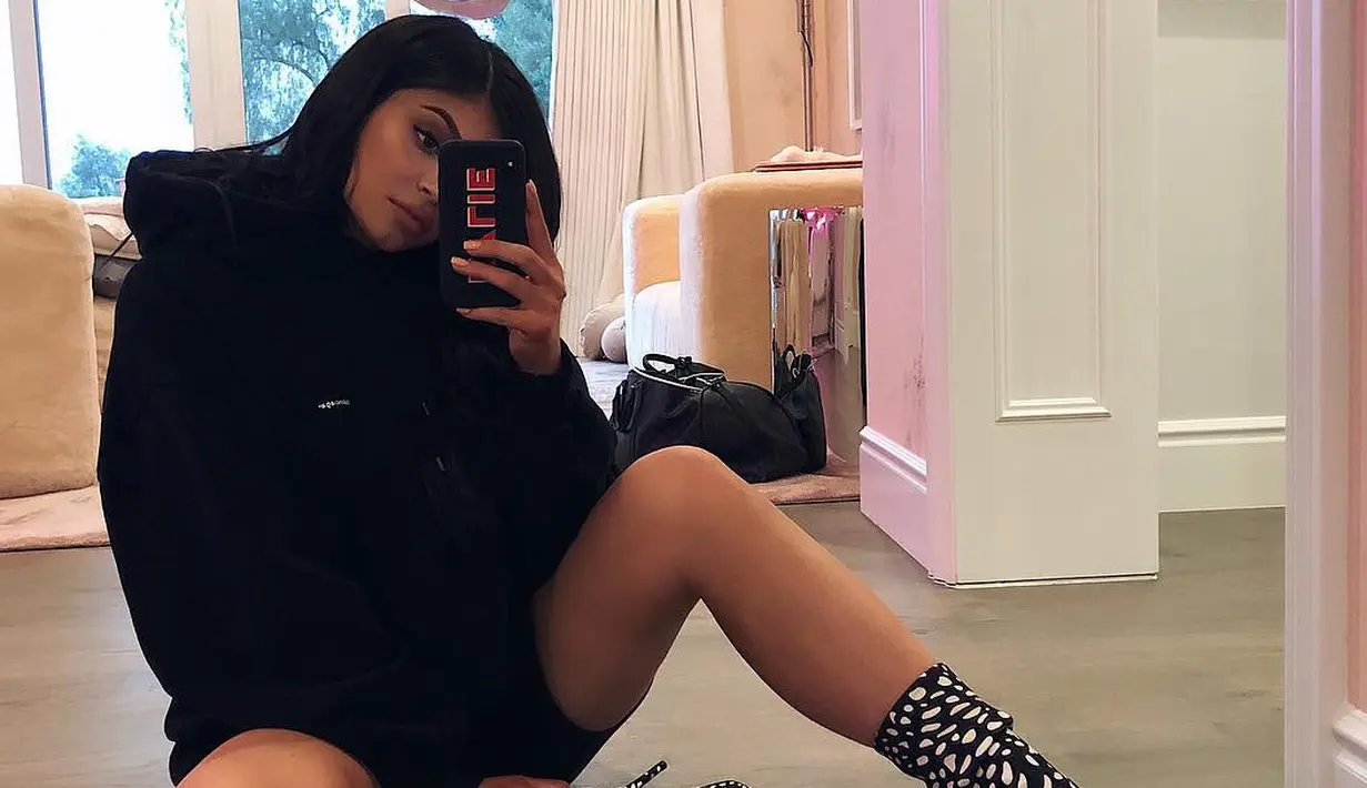 Ia terlihat cantik dengan oversized sweater berwarna hitam dan juga boots berwarna hitam putih. (instagram/kyliejenner)