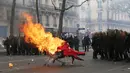 Pengunjuk rasa mendorong troli yang terbakar ke arah polisi anti huru hara Prancis selama demonstrasi perayaan May Day di Paris,Senin (1/5). Hari Buruh Internasional di Paris, diwarnai bentrokan antara pengunjuk rasa dengan polisi. (Zakaria ABDELKAFI/AFP)