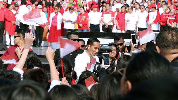 Presiden RI, Joko Widodo (tengah) menyapa peserta Harmoni Indonesia 2018 di Kompleks Gelora Bung Karno, Jakarta, Minggu (5/8). Harmoni Indonesia adalah bernyanyi bersama secara serentak lagu-lagu kebangsaan di 34 kota. (Liputan6.com/Helmi Fithriansyah)