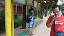 Seorang wanita menunggu di Halte Perum Tanjung Mas, Jakarta, Rabu (6/2). Proyek peninggian trotoar yang tidak diimbangi dengan renovasi halte menyebabkan bangku di halte menjadi pendek dan tidak layak untuk digunakan. (Liputan6.com/Immanuel Antonius)