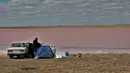 Wisatawan beristirahat di dekat Danau Kobeituz di Kawasan Akmola, Kazakhstan utara (20/6/2020). Danau Kobeituz terkenal dengan warna merah mudanya dan populer di kalangan wisatawan lokal. (Xinhua/Kalizhan Ospanov)
