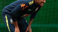 Striker Brasil, Neymar meringis merasakan sakit di pergelangan kaki kanannya pada sesi latihan di Sochi, Selasa (19/6). Neymar berhenti berlatih untuk persiapan pertandingan Piala Dunia kedua timnas Brasil melawan Kosta Rika. (AFP PHOTO / Adrian DENNIS)
