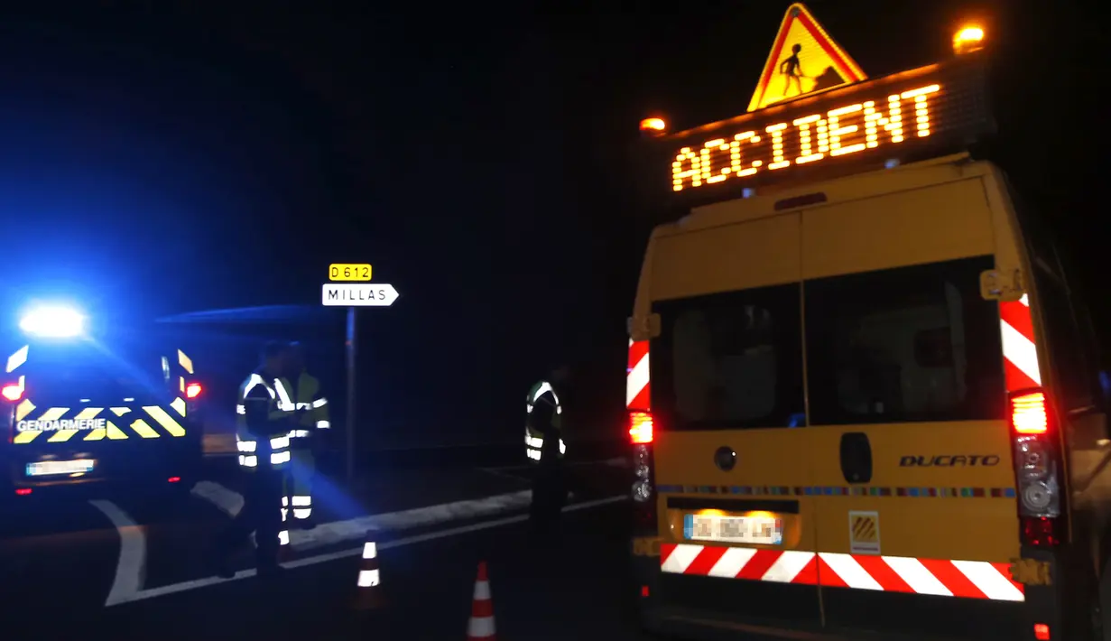 Petugas kepolisian menutup jalan dekat lokasi kecelakaan maut antara kereta dengan bus sekolah di dekat Perpignan, Prancis selatan, Kamis (14/12). Radio regional Perancis, Bleu, melaporkan kereta tersebut menabrak bagian belakang bus. (RAYMOND ROIG/AFP)