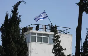 Foto-foto yang diperoleh Associated Press dan staf UNRWA pada Senin (8/12/2025) menunjukkan polisi mengibarkan bendera Israel dan memasuki area kompleks. (Dok. AP Photo/Mahmoud Illean)
