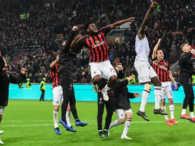 Gelandang AC Milan, Franck Kessie (tengah) dan rekan setimnya merayakan kemenangan bersama suporter usai pertandingan melawan Lazio pada lanjutan Liga Serie A Italia di stadion San Siro (13/4). Milan menang tipis 1-0 atas Lazio berkat gol penalti Kessie. (AFP Photo/Miguel Medina)