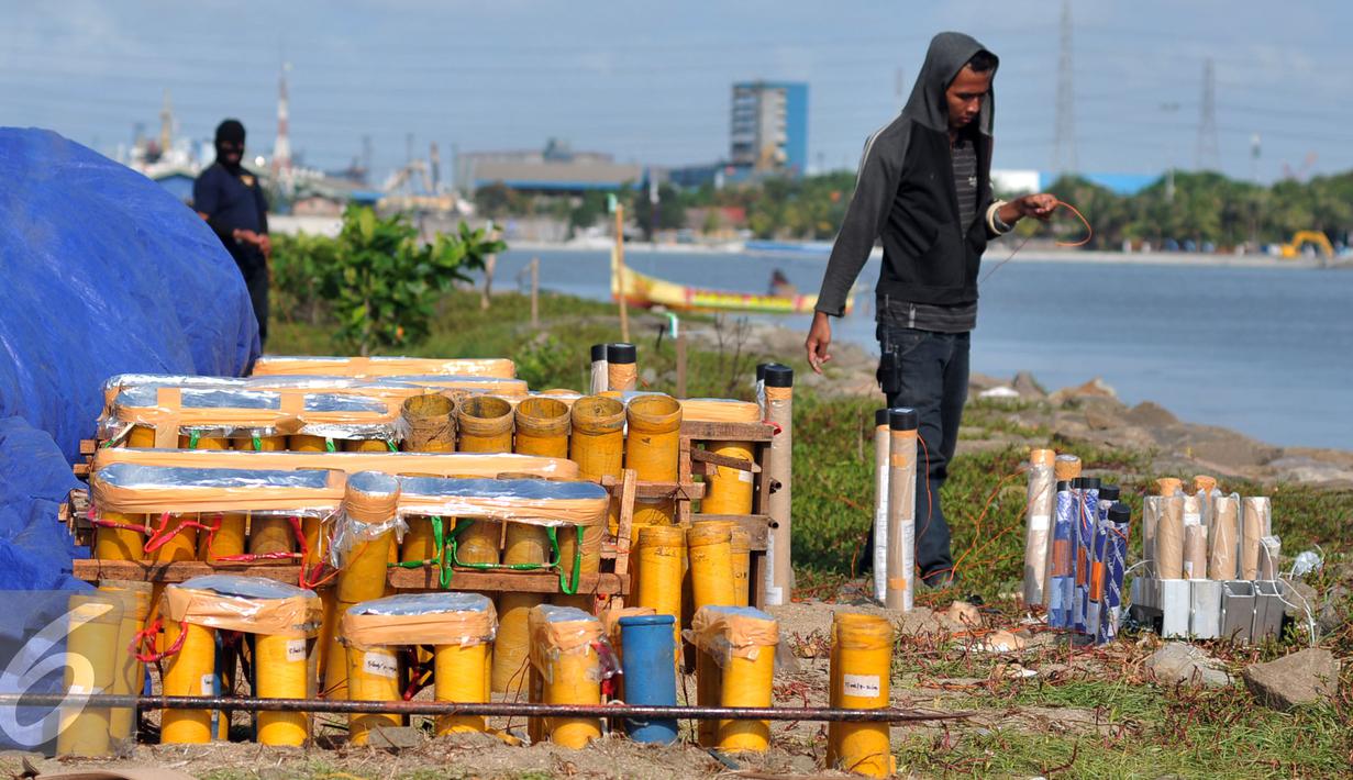 Pekerja menyambungkan kabel kepada pipa-pipa kembang api untuk dinyalakan saat perayaan malam tahun baru 2016 di pantai Ancol, Jakarta, Rabu (30/12). (Liputan6.com/Yoppy Renato)