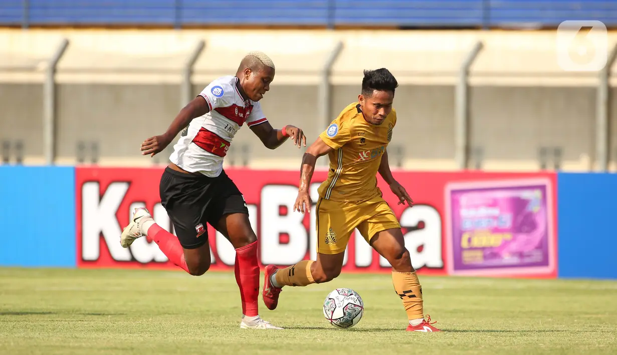 Pemain Madura United Hugo Gomes Dos Santos Silva (kiri) berusaha menghalau pemain Bhayangkara FC Andik Vermansah (kanan) dalam pertandingan BRI Liga 1 2021/2022 antara Bhayangkara FC melawan Madura United di Stadion Si Jalak Harupat, Kabupaten Bandung, Sabtu (18/9/2021). (Bola.com/Ikhwan Yan