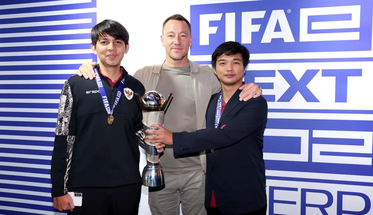 Tim Indonesia yang diwakili oleh Ichsan Rahmat Taufiq sebagai manajer dan Budi Muhamad Manar Hidayat sebagai asisten foto bersama legenda Chelsea, John Terry, usai menjuarai FIFAe World Cup Football Manager 2024 di Liverpool, Inggris. (Dok. FIFAe)