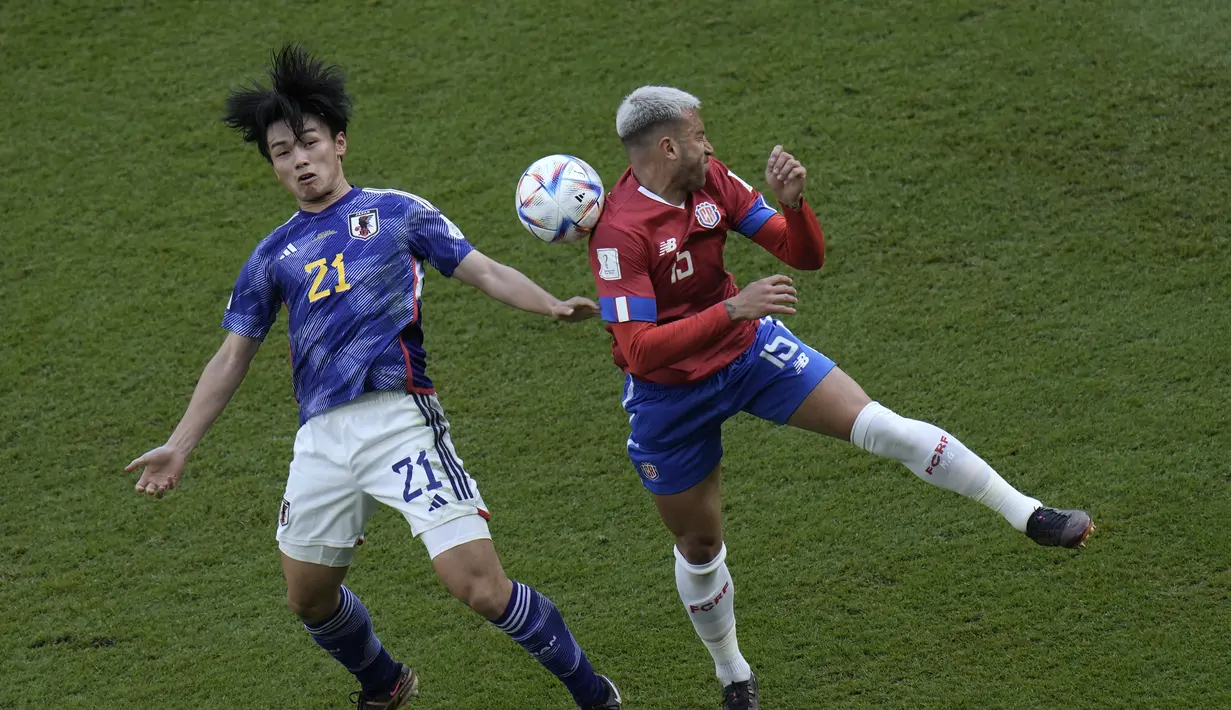 Bek Kosta Rika, Francisco Calvo berebut bola dengan penyerang Jepang, Ayase Ueda selama pertandingan grup E Piala Dunia 2022 Qatar di Stadion Ahmad Bin Ali di Al Rayyan, Qatar, Minggu, 27 November 2022. Kemenangan ini membuat Kosta Rika berada diperingkat ketiga dengan tiga poin. (AP Photo/Hassan Ammar)