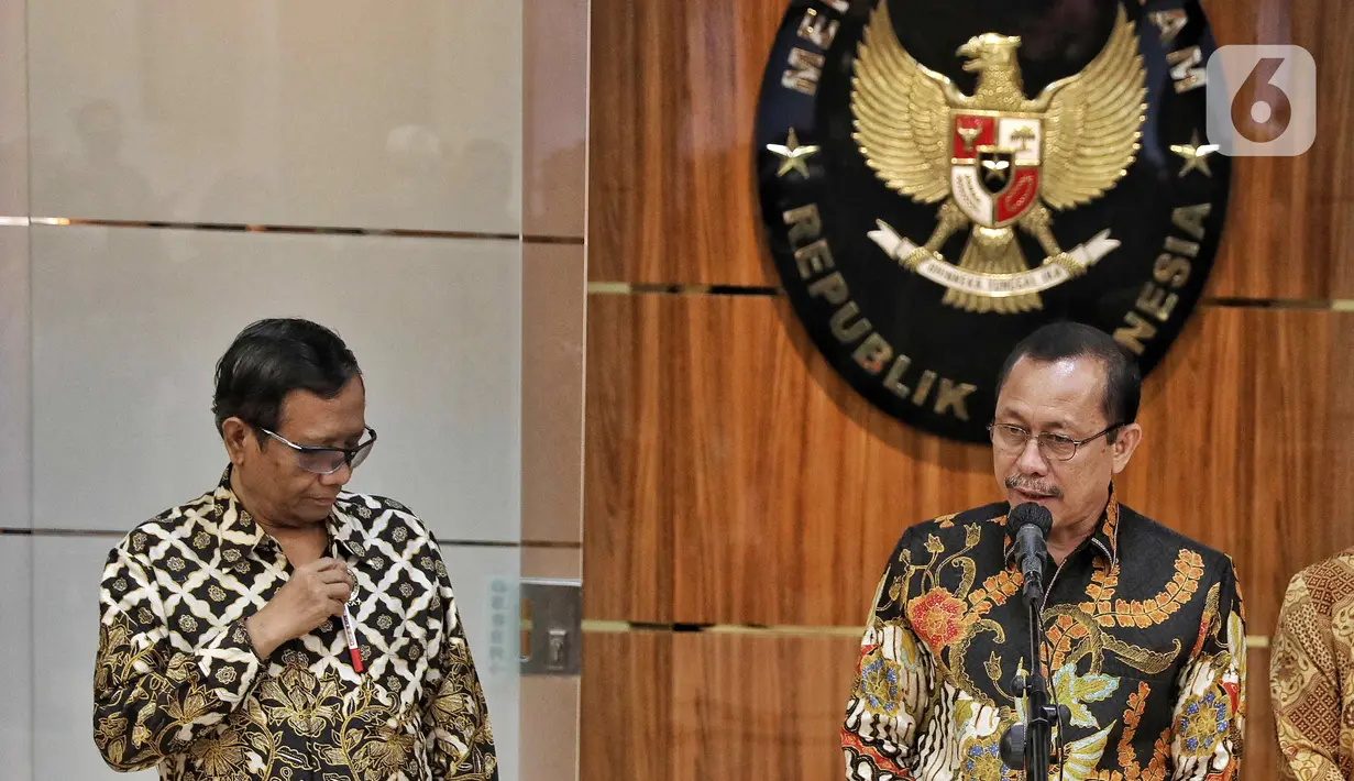 Ketua Komnas HAM Ahmad Taufan Damanik (kanan) bersama Menteri Koordinator Bidang Politik, Hukum, dan Keamanan (Menko Polhukam) Mahfud MD (kiri) menyampaikan keterangan di sela penyerahan berkas laporan terkait investigasi tragedi Kanjuruhan di Kantor Menko Polhukam, Jakarta, Kamis (3/11/2022). Menko Polhukam mewakili Presiden Joko Widodo atau Jokowi menerima laporan terkait investigasi tragedi Kanjuruhan yang berisi rekomendasi untuk membekukan seluruh kegiatan PSSI. (Liputan6.com/Angga Yuniar)
