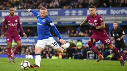 Striker Everton Wayne Rooney melakukan tendangan saat melawan Manchester City dalam pertandingan Liga Inggris di Goodison Park di Liverpool (31/3). Kemenangan ini membuat Manchester City makin dekat meraih gelar juara Premier League.(AFP Photo/Paul Ellis)