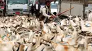 Lelaki Yaman berdiri di antara kawanan kambing di pasar ternak menjelang Idul Adha di ibu kota Sanaa, 6 Agustus 2019. Umat Islam di seluruh dunia akan merayakan Idul Adha yang identik dengan tradisi berkurban menggunakan hewan seperti kambing, domba, unta, sapi dan kerbau. (MOHAMMED HUWAIS/AFP)