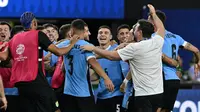 Gelandang Uruguay, Manuel Ugarte (tengah) merayakan dengan rekan setimnya setelah mencetak gol dalam adu penalti untuk memenangkan pertandingan perempat final Copa America 2024 melawan Brasil di Stadion Allegiant, Las Vegas, Nevada pada 6 Juli 2024 atau Minggu 7 Juli 2024 WIB. (Robyn BECK/AFP)