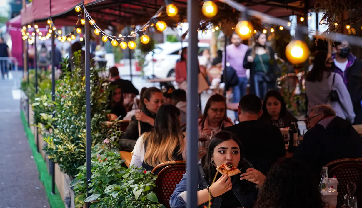 Pengunjung duduk di luar restoran yang menawarkan layanan area luar ruangan (outdoor) di New York pada 3 Oktober 2020. Kota itu mengizinkan restoran membuat area makan outdoor hingga ke trotoar dan jalanan sebagai upaya mengatasi dampak ekonomi COVID-19 yang berkelanjutan. (AP Photo/John Minchillo)