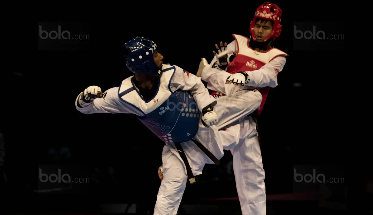Atlet taekwondo Indonesia, Dinggo Ardian (merah), saat melawan Morrison Samuel, pada final kelas kyorugi -74 kg SEA Games di KLCC, Kuala Lumpur, Minggu (27/8/2017). Kalah di final, Dinggo harus puas meraih perak. (Bola.com/Vitalis Yogi Trisna)