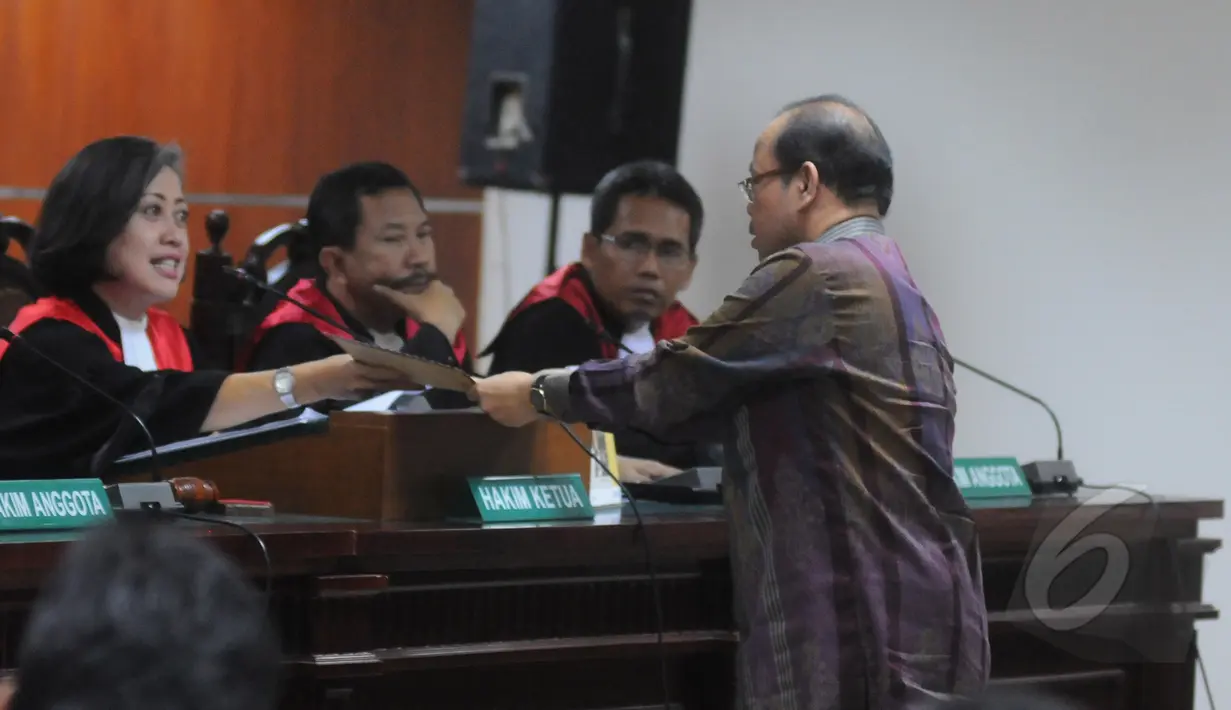Sutan Bhatoegana menyerahkan berkas kepada hakim saat sidang perdana di Pengadilan Tipikor, Jakarta, Senin (6/4/2015). Tanpa didampingi tim kuasa hukumnya, Sutan Bhatoegana menjalani sidang perdananya. (Liputan6.com/Herman Zakharia)
