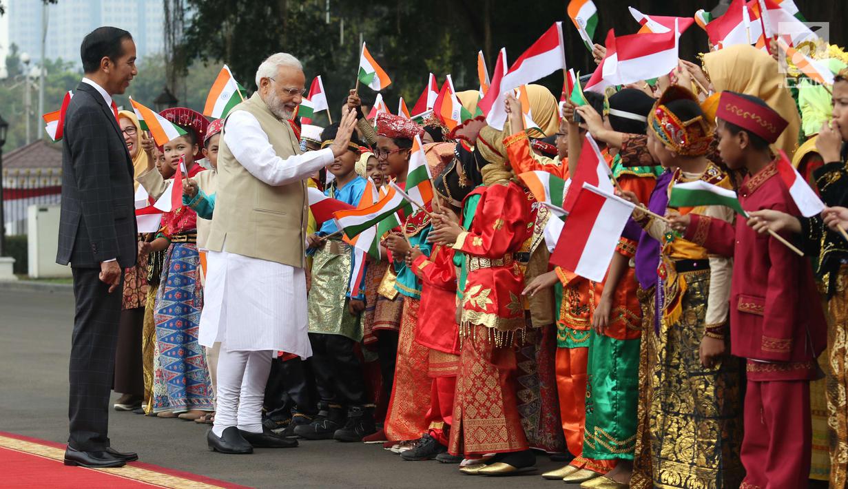 Perdana Menteri (PM) India, Narendra Modi didampingi Presiden Joko Widodo (Jokowi) bersalaman dengan murid Sekolah Dasar berpakaian adat Indonesia dalam upacara penyambutan di Istana Merdeka, Jakarta, Rabu (30/5). (Liputan6.com/Angga Yuniar)