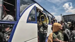 Massa FRI-West Papua menaiki bus saat dibubarkan oleh aparat kepolisian terkait aksi peringatan Deklarasi 1 Desember 1961 di kawasan Monas, Jakarta, Selasa (1/12/2020). Massa menolak perpanjangan otonomi khusus dan menuntut hak nasib rakyat West Papua. (merdeka.com/Iqbal S. Nugroho)