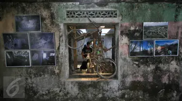 Pengunjung menyaksikan pameran foto peringatan 5 tahun letusan Merapi 2010 di Dusun Petung,Sleman,  Yogyakarta, Kamis (29/10/2015). Pameran bertempat di bekas pemukiman warga yang menjadi saksi bisu saat terjangan lahar panas erupsi Merapi. (Boy Harjanto)