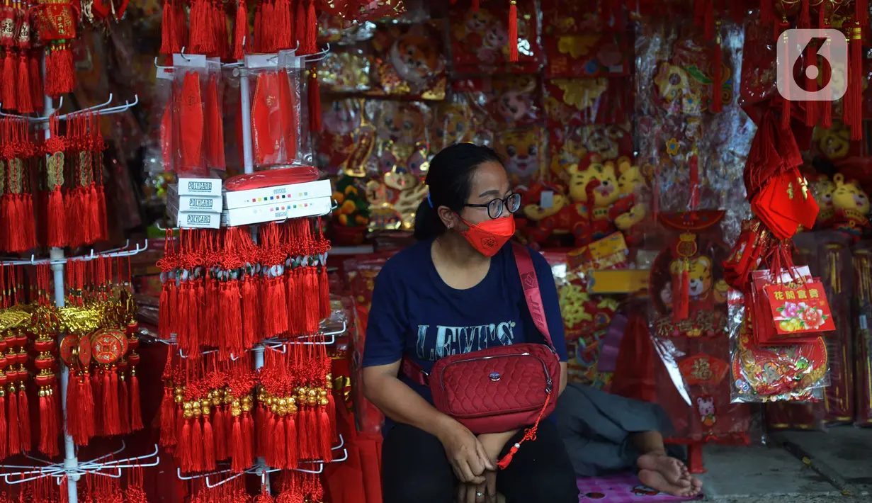 Pedagang menunggu pembeli pernak-pernik Imlek di pasar Petak Sembilan, Glodok, Jakarta, Selasa (18/1/2022).  Di tengah masa pandemi Covid-19 dengan varian Omicron, beberapa penjual mengatakan belum mengalami lonjakan pembeli yang mencari pernak-pernik perayaan Imlek. (merdeka.com/Imam Buhori)