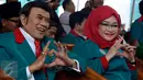 Ketum Partai Idaman Rhoma Irama (kiri) dan istri Rica Rachim menunjukkan lambang partai dengan jari saat deklarasi di Tugu Proklamasi, Jakarta, Rabu (14/10). Deklarasi itu dihadiri sejumlah tokoh parpol dan simpatisan partai. (Liputan6.com/Yoppy Renato)