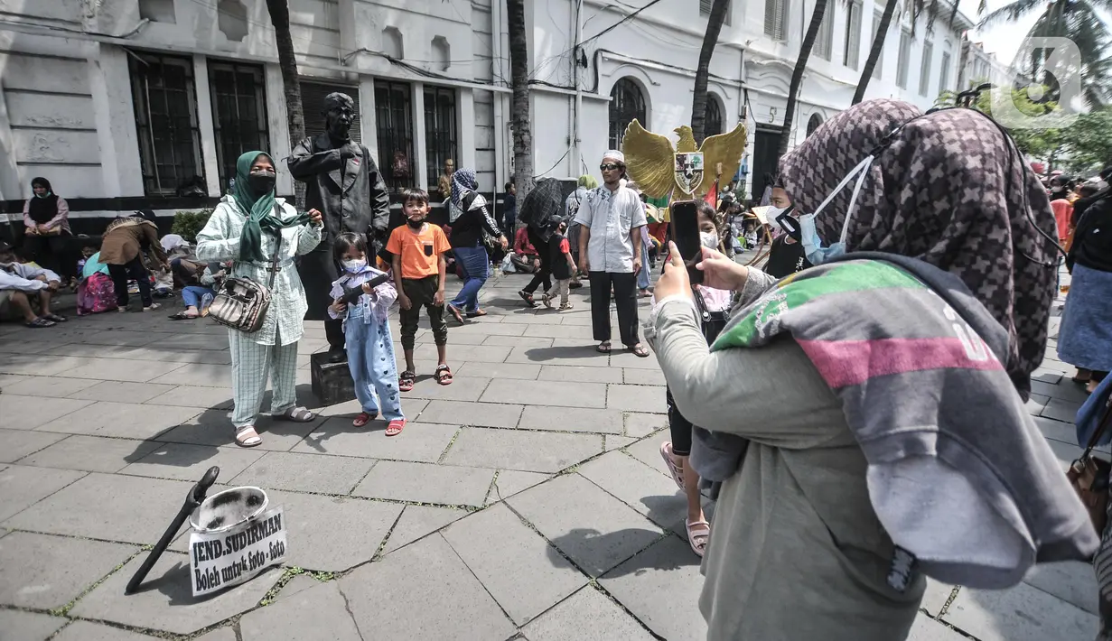 <p>Wisatawan berswafoto saat mengunjungi kawasan Kota Tua, Jakarta, Rabu (4/5/2022). Kawasan Kota Tua menjadi salah satu destinasi favorit warga baik dari dalam maupun luar Jakarta untuk mengisi waktu libur Lebaran bersama keluarga. (merdeka.com/Iqbal S Nugroho)</p>