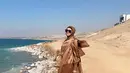 Mengunjungi Laut Mati, Mulan Jameela pun tidak lupa abadikan momen saat berada di pinggir pantai. Berlatar belakang pemandangan khas negara di Timur Tengah, penampilannya yang dengan buasana coklat ini menuai banyak pujian. (Liputan6.com/IG/mulanjameela1)
