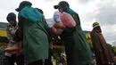 Petugas mengangkat Nur Elita, terpidana pelanggar hukum syariat, yang pingsan saat menjalani eksekusi hukuman cambuk di halaman Masjid Baiturrahim Ulee Lheue, Banda Aceh, Senin (28/12). (AFP/dailymail.co.uk)