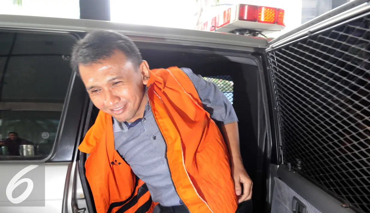 Gatot Pujo Nugroho saat keluar dari dalam mobil tahanan untuk memenuhi panggilan penyidik KPK, Jakarta, Jumat (11/12). Pemandangan menarik dan lucu ketika Gatot tak sadar mengenakan rompi tahanan KPK yang ternyata terbalik. (Liputan6.com/Helmi Afandi)