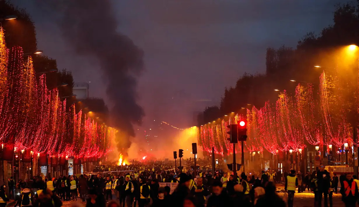 Asap membumbung saat kerusuhan menentang kenaikan harga bahan bakar di Paris, Prancis, Sabtu (24/11). Demonstrasi ini merupakan aksi kedua setelah unjuk rasa serupa yang dilakukan pekan lalu. (AP Photo/Christophe Ena)