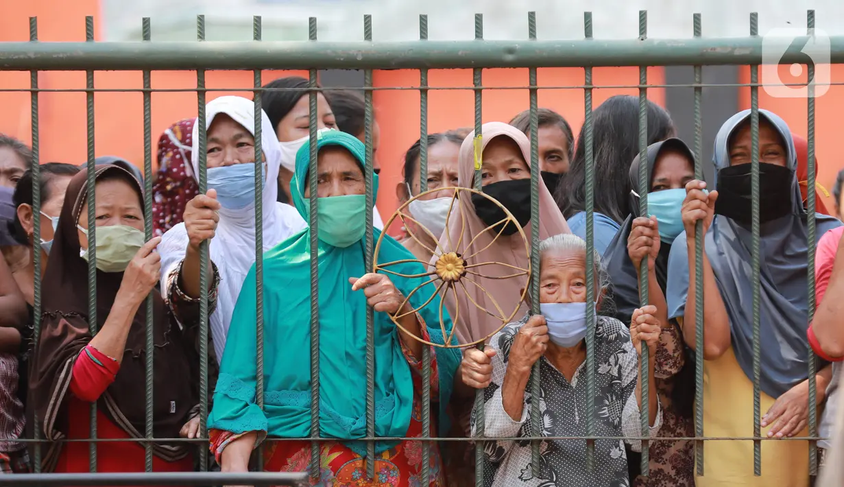 Warga antre menunggu untuk mendapatkan daging kurban di Kelurahan Menteng, Jakarta Pusat, Sabtu (1/8/2020). Pembagian daging kurban tersebut berjalan lancar meskipun sebagian warga mengabaikan protokol Kesehatan. (Liputan6.com/Angga Yuniar)