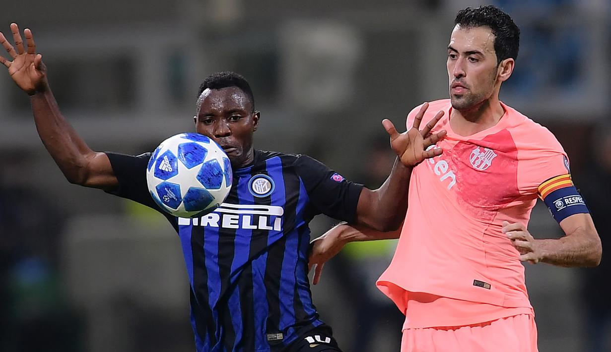 Gelandang Inter Milan, Kwadwo Asamoah, berebut bola dengan gelandang Barcelona, Sergio Busquets, pada laga Liga Champions di Stadion San Siro, Milan, Selasa (6/11). Kedua klub bermain imbang 1-1. (AFP/Marco Bertorello)