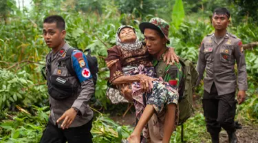 Tim SAR menggendong seorang wanita tua ke tempat aman setelah tanah longsor melanda di Gowa, Sulawesi Selatan, Jumat (25/1). Hingga 25 Januari 2018, tercatat 33 orang meninggal dunia. (YUSUF WAHIL/AFP)