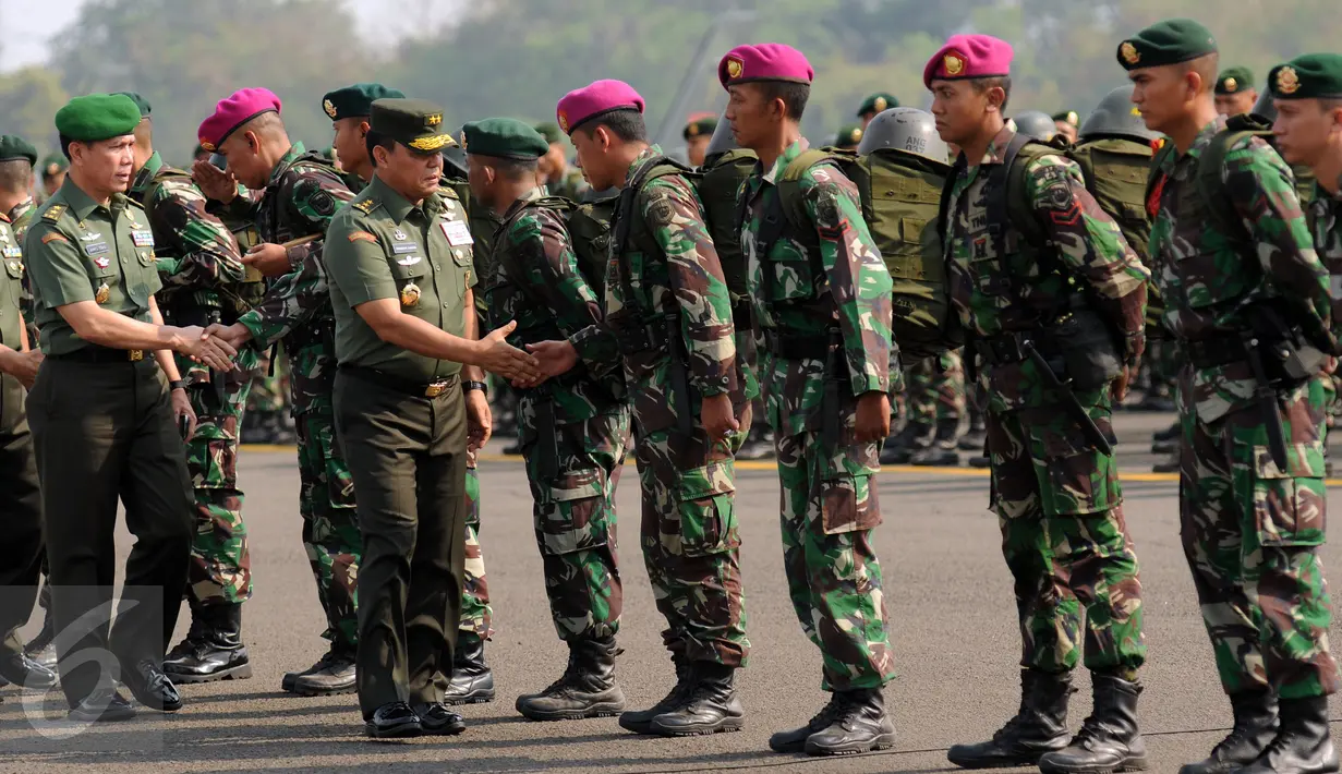 AsOps Panglima TNI, Mayjen TNI Fransen G Siahaan (kanan depan) menyalami pasukan yang akan menuju Sumatera Selatan di Lanud Halim Perdanakusuma Jakarta, Kamis (22/10/2015). Satgas ini akan bertugas selama dua bulan. (Liputan6.com/Helmi Fithriansyah)