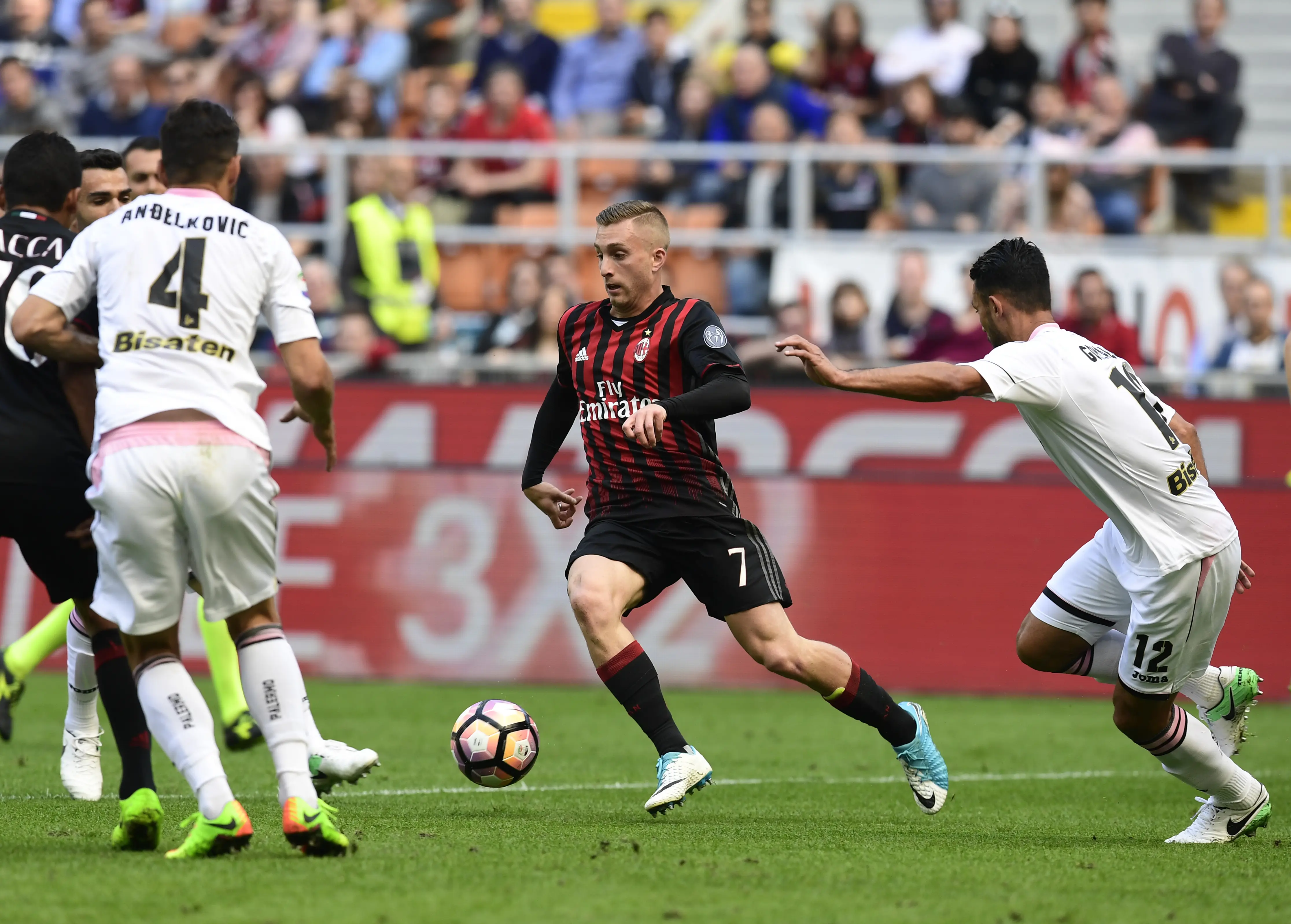 Aksi bomber AC Milan, Gerard Deulofeu (tengah) saat berusaha melepaskan diri dari penjagaan dua bek Palermo, Gincarlo Gonzalez dan Sinisa Andelkovic, Minggu (9/4/2017). (AFP/Miguel Medina)