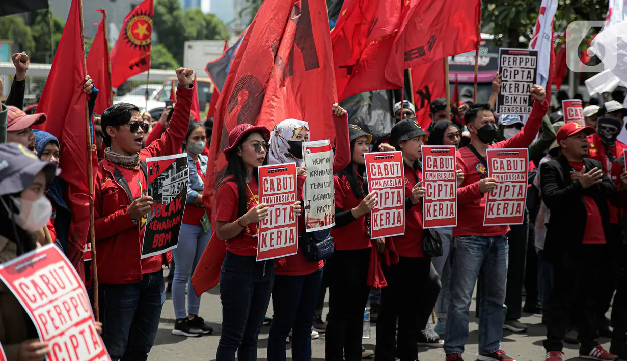 Elemen buruh menggelar aksi unjuk rasa di gedung DPR RI, Jakarta, Selasa (10/1/2023). Massa aksi yang menolak Perppu Cipta Kerja tersebut terlihat membawa bendera berwarna merah memenuhi halaman depan gedung DPR. (Liputan6.com/Faizal Fanani)