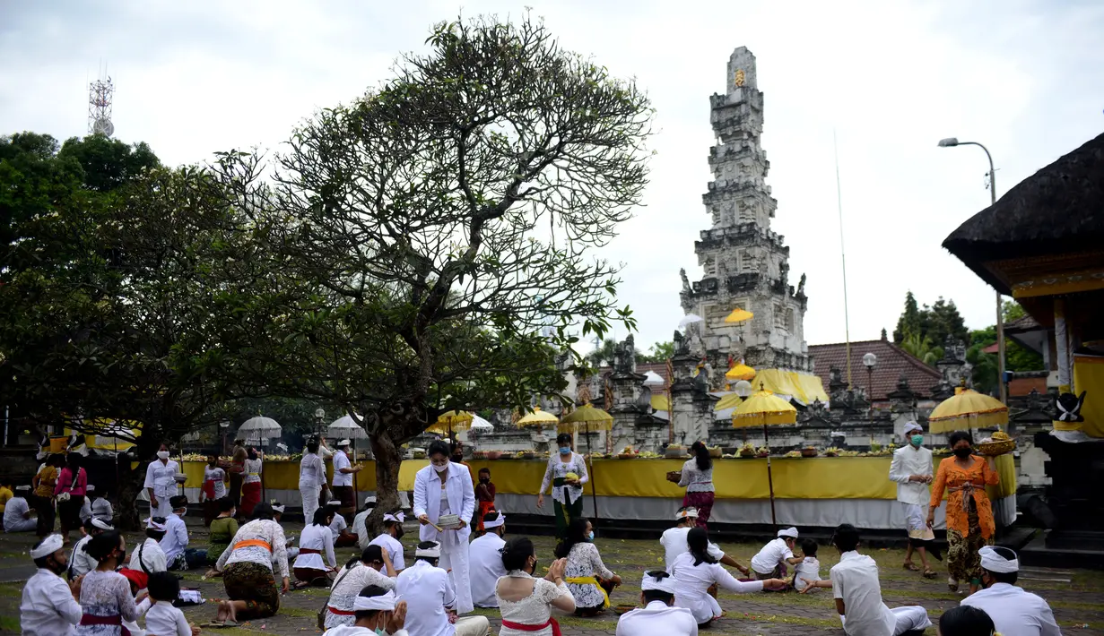 Umat Hindu berdoa untuk merayakan Hari Raya Galungan di Pura Jagat Natha di Denpasar, di pulau Bali (16/9/2020). Galungan dirayakan umat Hindu di Bali sebagai hari kemenangan Dharma (Kebaikan) melawan Adharma (Keburukan). (AFP Photo/Sonny Tumbelaka)