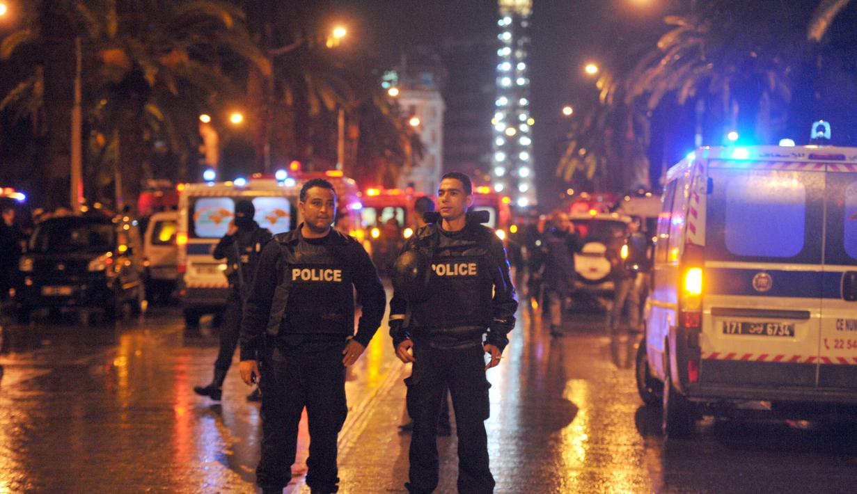 Petugas memblokir jalan menuju lokasi ledakan di sebuah bus yang mengangkut pengawal Presiden Tunisia di Tunis, Selasa (24/11). Insiden yang diduga akibat serangan bom bunuh diri itu menewaskan 12 orang dan melukai 16 lainnya. (AFP PHOTO/Fethi Belaid)