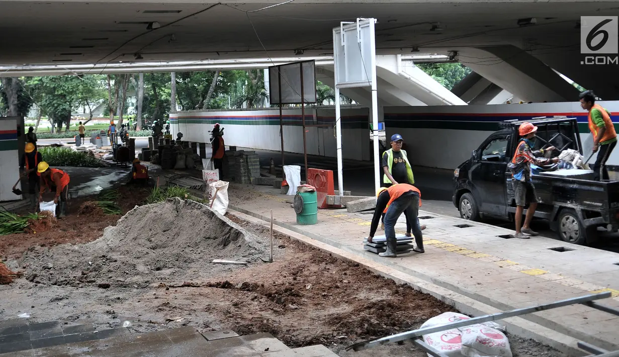 Aktivitas pekerja saat menyelesaikan pembangunan taman di kolong Jembatan Semanggi, Jakarta, Kamis (7/3). Taman kolong Jembatan Semanggi nantinya akan difungsikan sebagai pusat interaksi warga. (merdeka.com/Iqbal Nugroho)