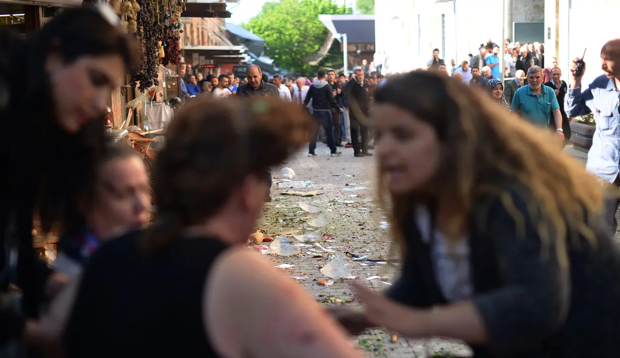 Seorang wanita memberikan pertolongan pertama pada korban luka akibat ledakan di Bursa, bagian barat Turki, Rabu (27/4). Pihak kepolisian menyatakan ledakan tersebut berasal dari bom bunuh diri, yang dilakukan oleh seorang wanita. (Onur YURTSEVER/AFP)