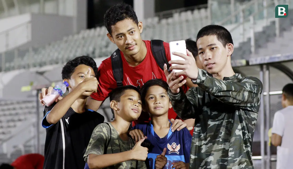 Fans cilik foto bersama dengan kiper Timnas Indonesia U-19, Erlangga Setyo, usai melakukan latihan jelang Piala AFF U-19 2022 di Stadion Madya, Jakarta, Selasa (21/6/2022). (Bola.com/M Iqbal Ichsan)