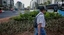 Pejalan kaki melintasi jalur hijau usai pembongkaran instalasi bambu Getah Getih di Bundaran HI, Jakarta, Kamis (18/7/2019). Masyarakat kini bisa melihat jelas Monumen Selamat Datang dari halte transjakarta Bundaran HI tanpa terhalang karya seni bernilai Rp550 juta itu. (Liputan6.com/Faizal Fanani)