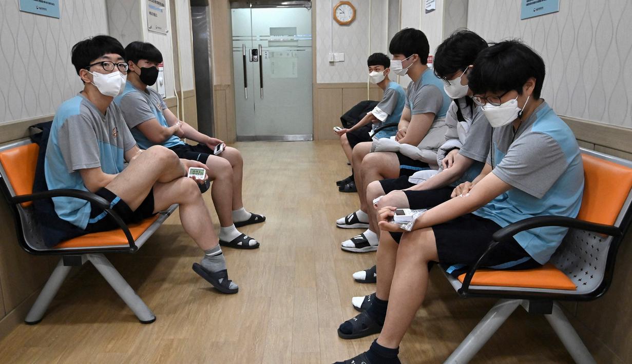 Sejumlah pemuda Korea Selatan menekan lengan mereka setelah melakukan tes darah saat pemeriksaan medis untuk wajib militer di Administrasi Tenaga Kerja Militer Regional Seoul, Seoul, Korea Selatan, Rabu (1/2/2023). Peraih medali Olimpiade dan Asian Games untuk Korea Selatan tidak diwajibkan untuk mengikuti wajib militer, juga bagi mereka yang pernah dibui lebih dari 6 tahun. (Jung Yeon-je/AFP)